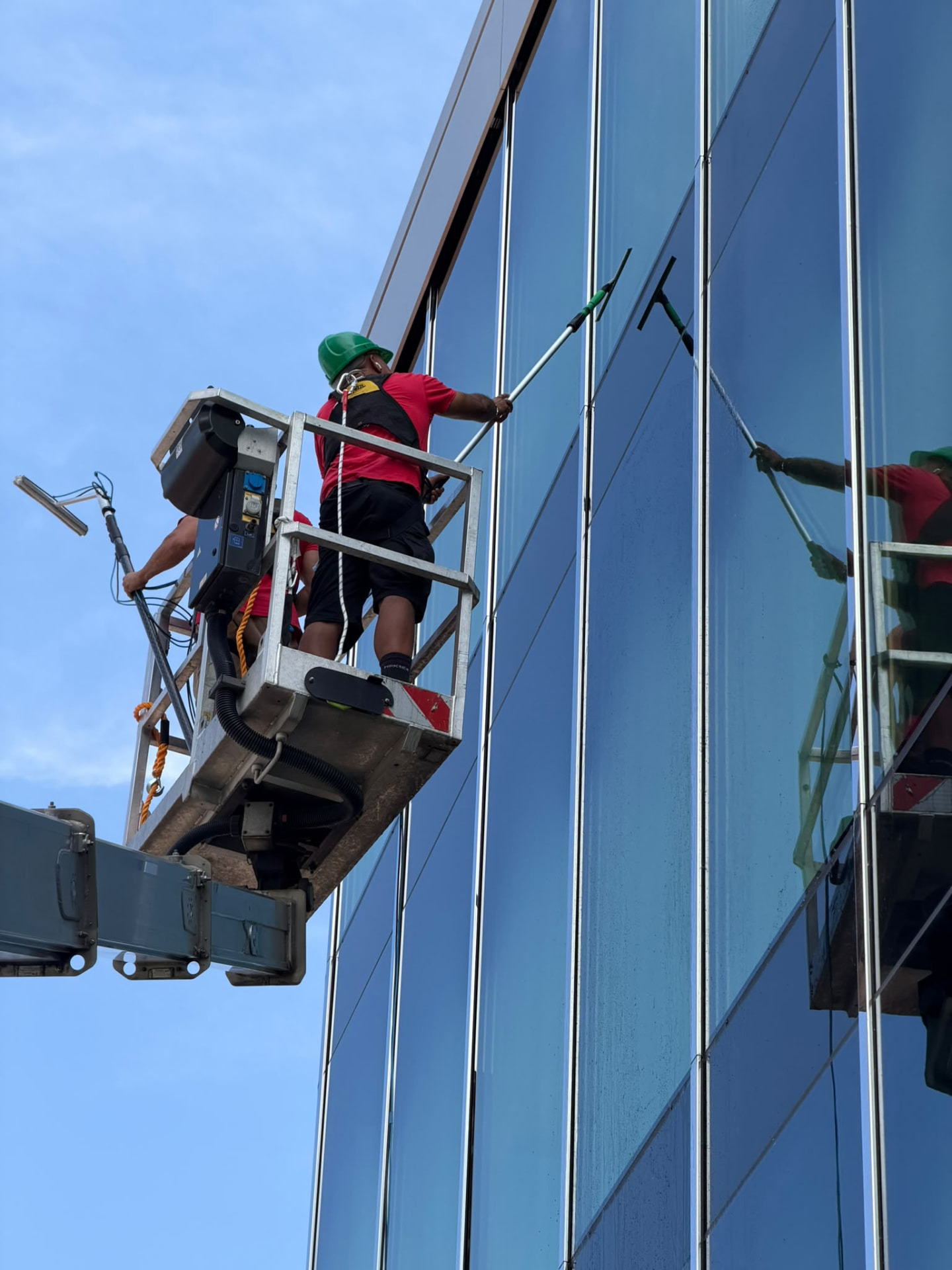 G-Raumpflege bei der Fensterreinigung auf einer Hebebühne